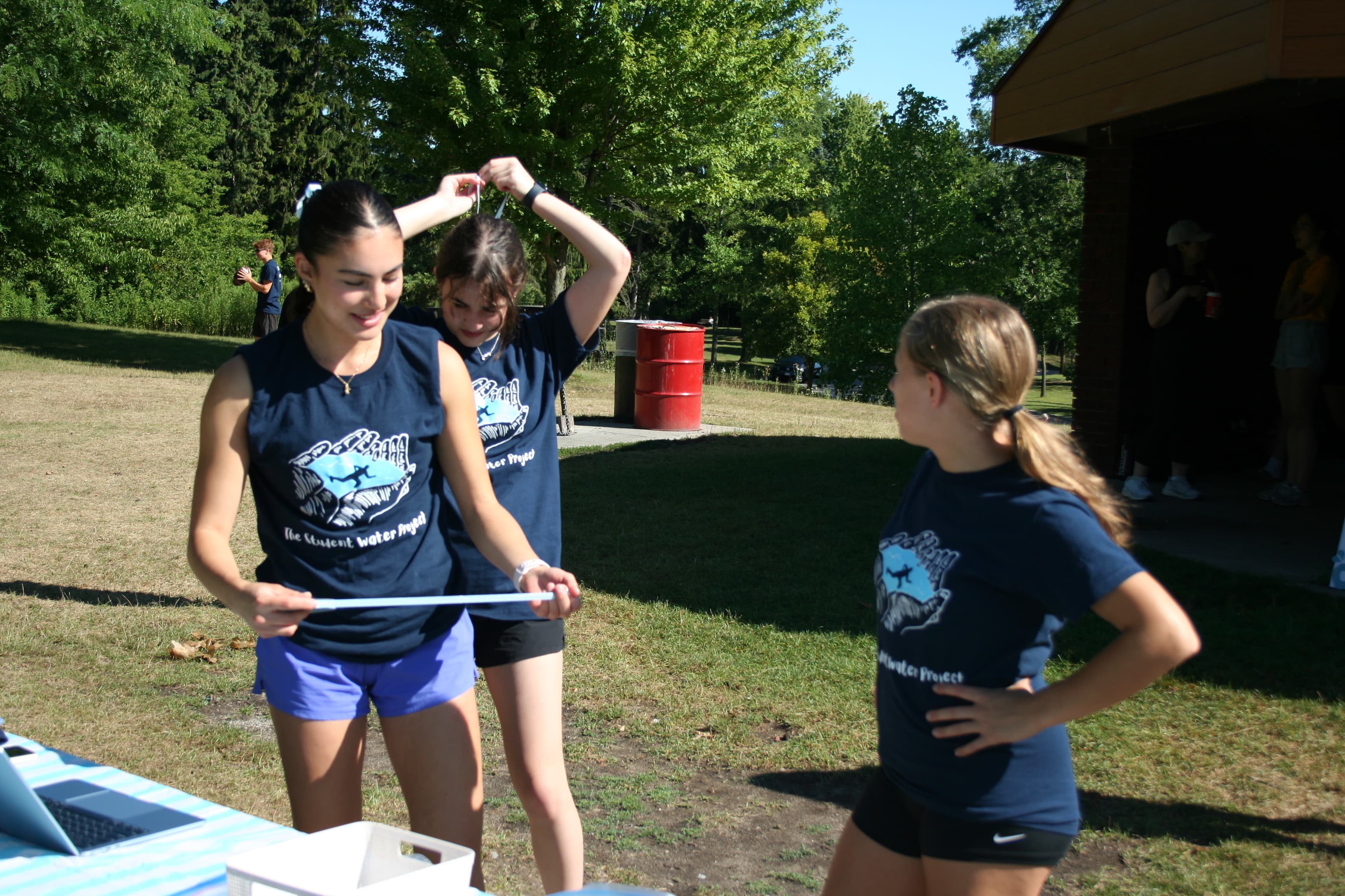 Volunteers in TSWP t-shirts chatting together outdoors at a team event